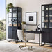 Crate & Barrel Caterina Natural Upholstered Office Chair with Brass Base positioned at a sleek black desk between tall storage cabinets in a contemporary office