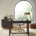 Crate & Barrel Caterina Natural Upholstered Office Chair with Brass Base styled at a dark wood desk in a bright home office with a large arched window