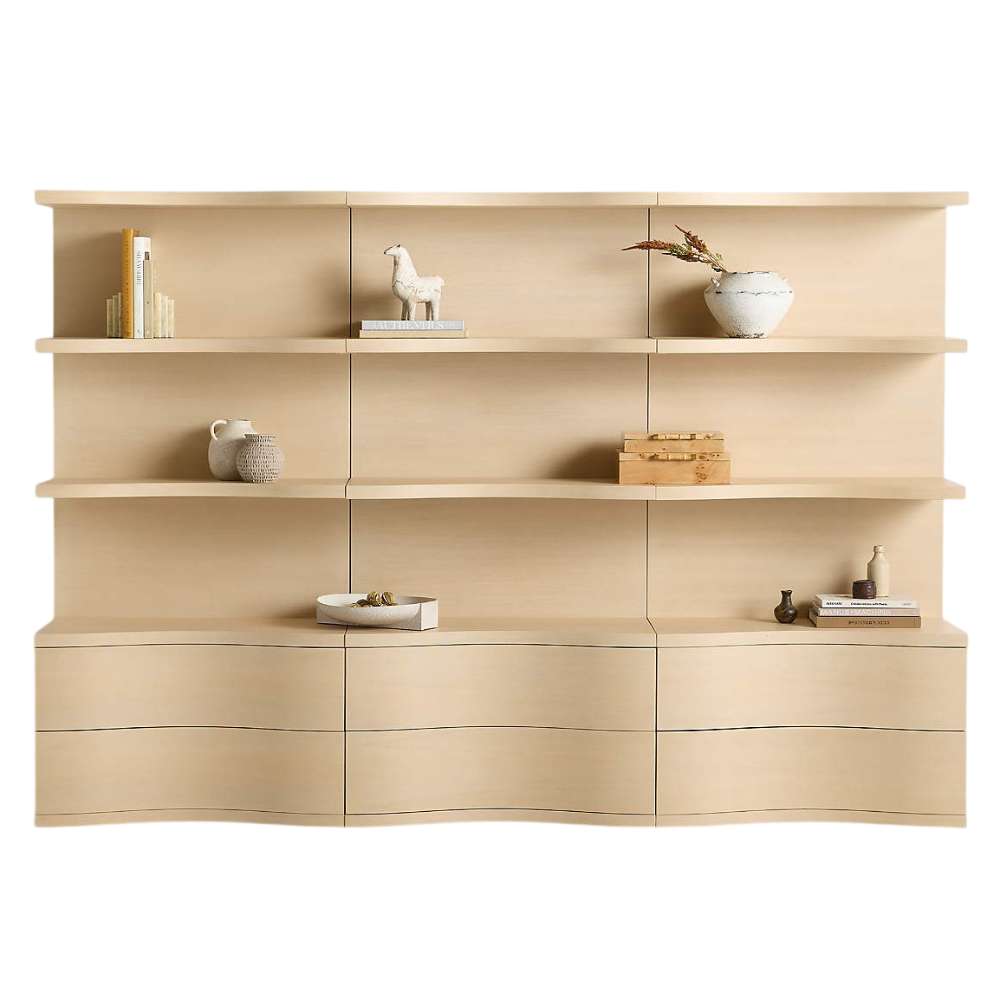 Crate & Barrel Coast 120" Whitewashed Oak Open Storage Bookcase, Set of 3 shown from the front with nine open shelves and six curved storage drawers styled with books and decorative accents