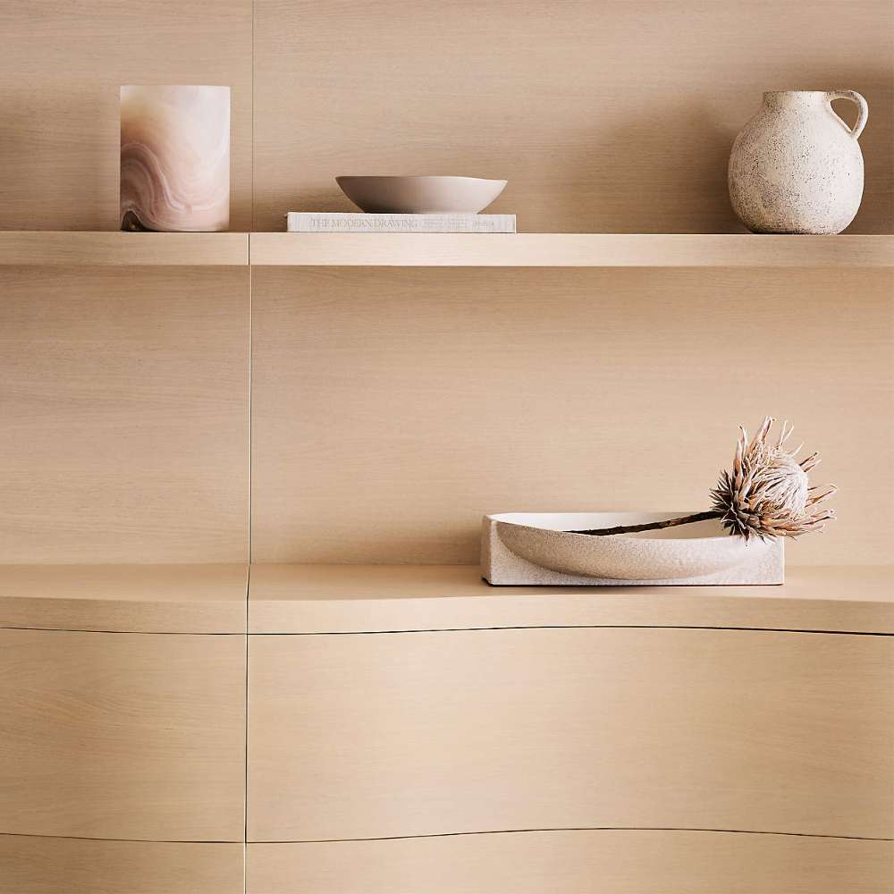 Crate & Barrel Coast 40" Whitewashed Oak Open Storage Bookcase close-up displaying decorative vases, books, and a tray arranged on the shelves