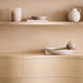 Crate & Barrel Coast 40" Whitewashed Oak Open Storage Bookcase close-up displaying decorative vases, books, and a tray arranged on the shelves