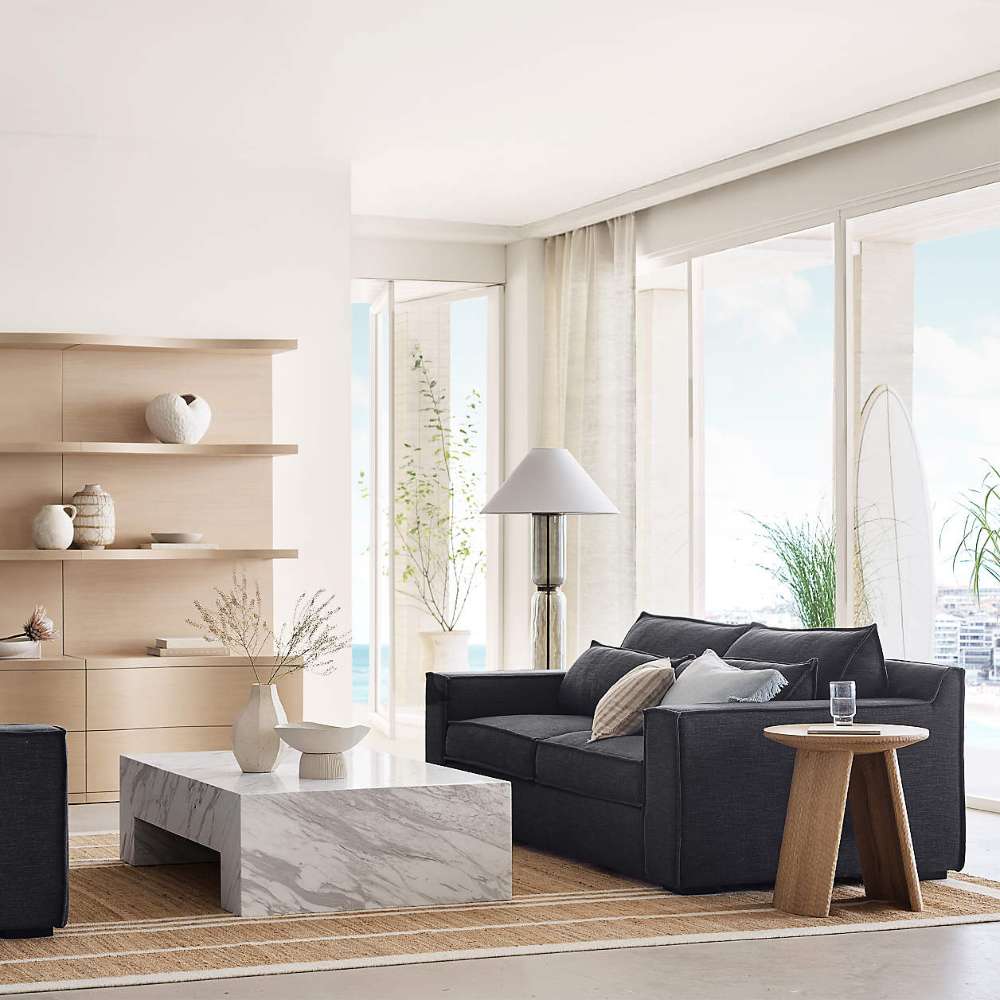 Crate & Barrel Coast 40" Whitewashed Oak Open Storage Bookcase styled in a bright living room with decorative objects on the open shelves