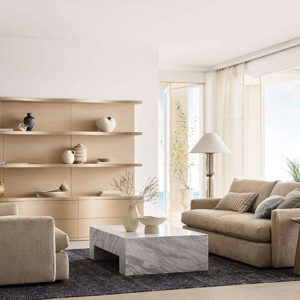 Crate & Barrel Coast 80" Whitewashed Oak Open Storage Bookcase, Set of 2 styled in a bright living room with decorative objects displayed across the wide open shelves