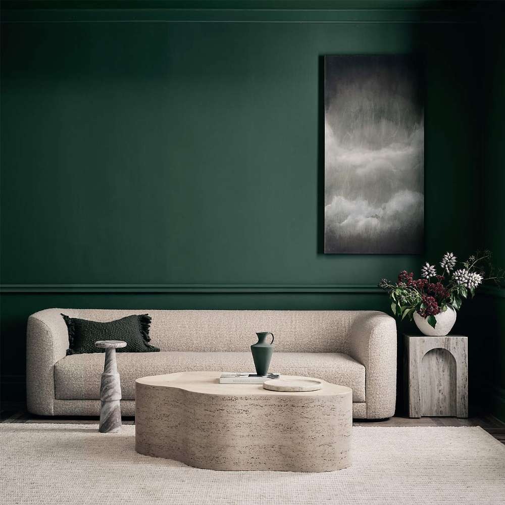 Crate & Barrel Contour Sofa styled in a modern living room with a stone coffee table, decorative pillows, and dark green walls