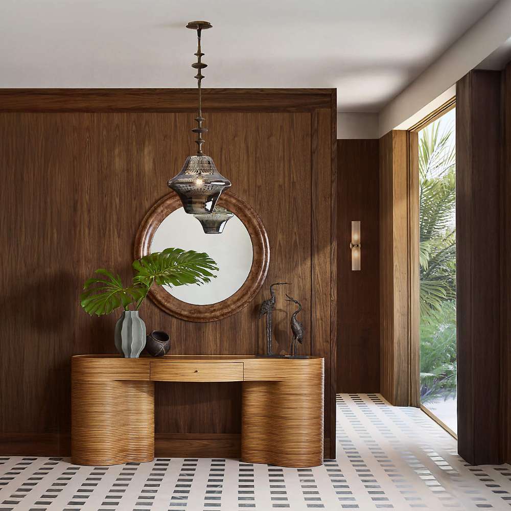 Crate & Barrel Delphine 73" Storage Console Table Desk styled in an entryway with decorative accents against rich wood-paneled walls