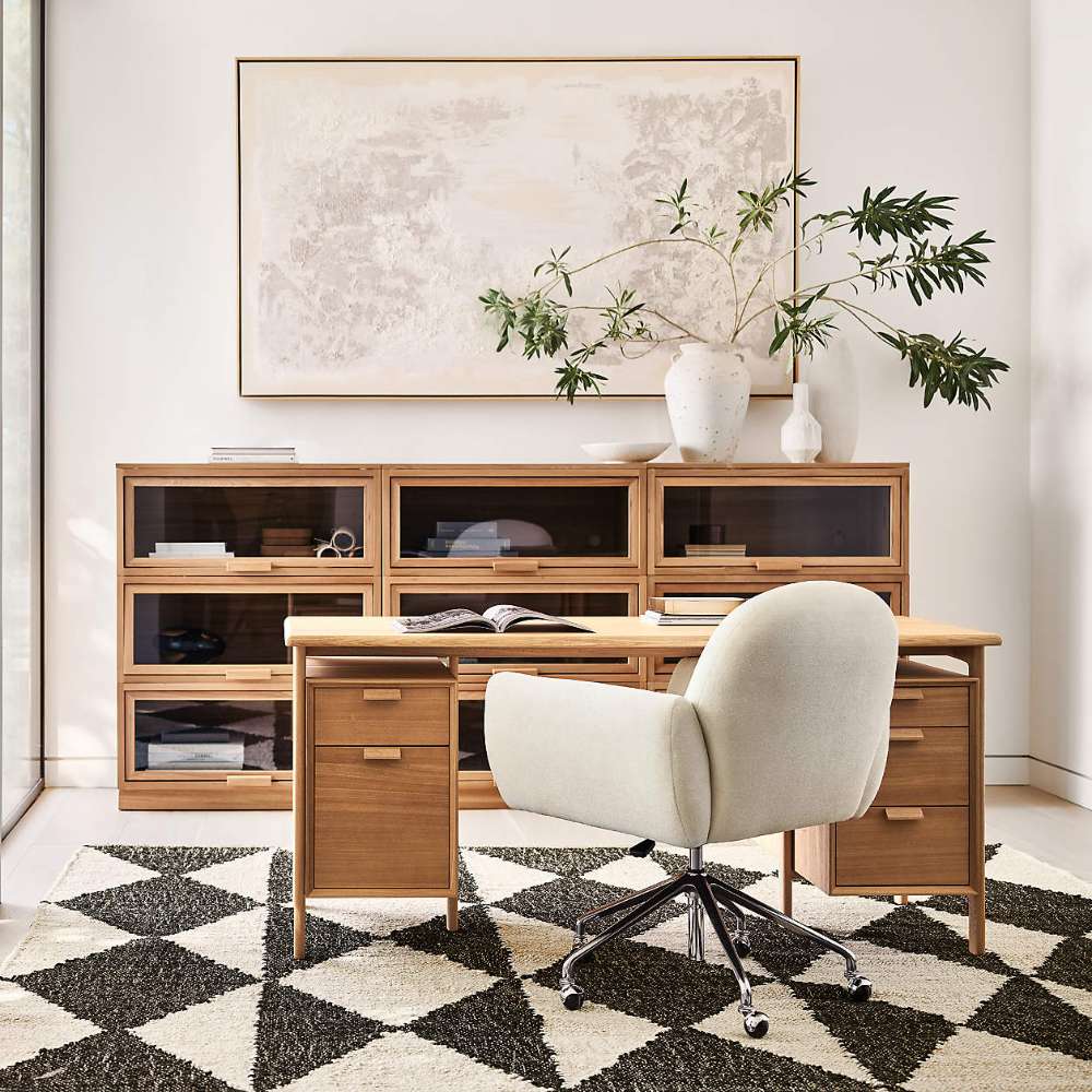 Crate & Barrel Elias 66" Natural Elm Wood Desk with File Cabinet is styled in a modern home office with matching storage cabinets and an upholstered swivel chair