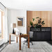 Crate & Barrel Emerson 60" Mappa Burl Desk styled in a modern home office with a task chair, table lamp, laptop, and black storage cabinets