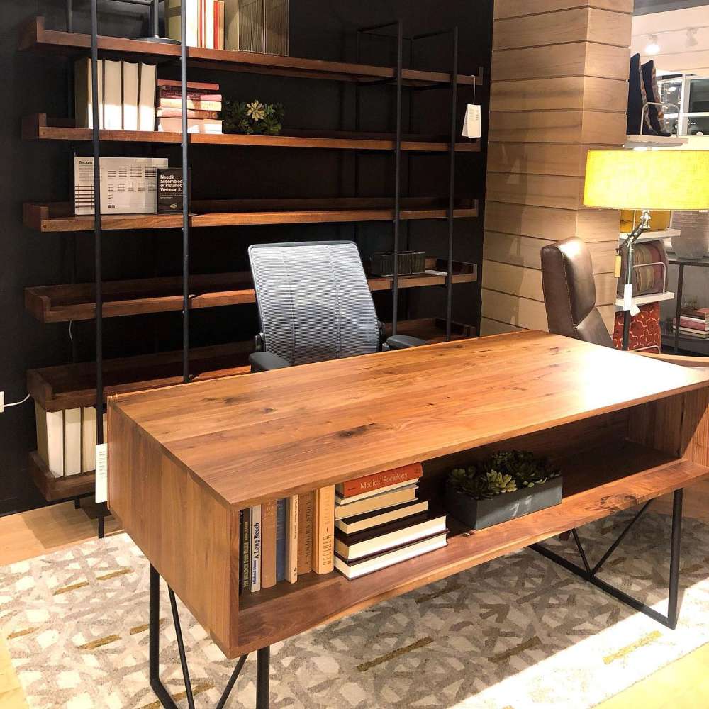 Crate & Barrel Humanscale® Smart Ocean Office Chair is shown behind a warm wood executive desk in a modern office with open shelving and books