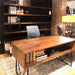 Crate & Barrel Humanscale® Smart Ocean Office Chair is shown behind a warm wood executive desk in a modern office with open shelving and books