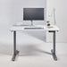 Crate & Barrel Humanscale® eFloat Go 2.0 60" White Adjustable Standing Charging Desk styled with a monitor, keyboard, mouse, desk lamp, and small plant in a modern workspace