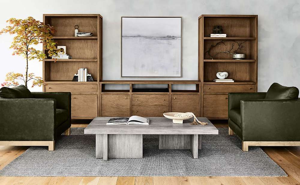 Crate & Barrel Keane 40" Driftwood Storage Bookcase, Set of 2 styled with books and decor in a modern living room
