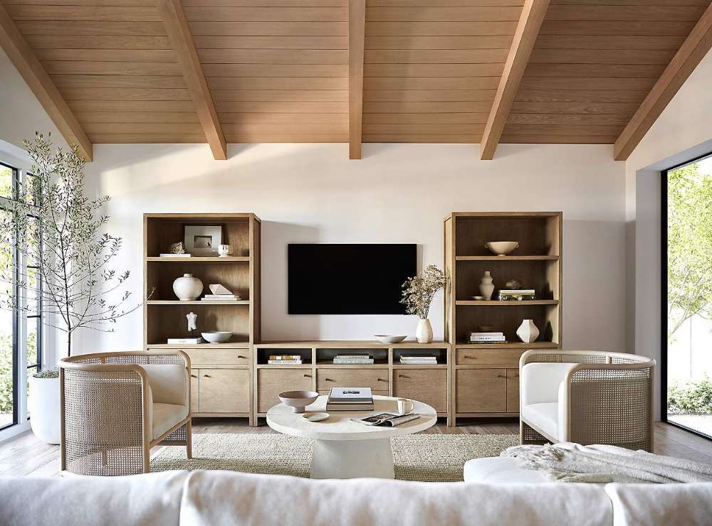 Crate & Barrel Keane 40" Natural Storage Bookcase, Set of 2 flanking a TV console with open shelves and concealed storage in a bright living room