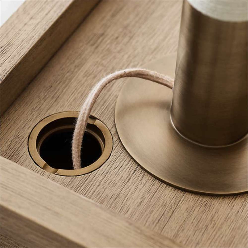 Crate & Barrel Keane 48" Weathered Natural Wood Desk with Outlets close-up of the desktop cable management opening with a cord routed through
