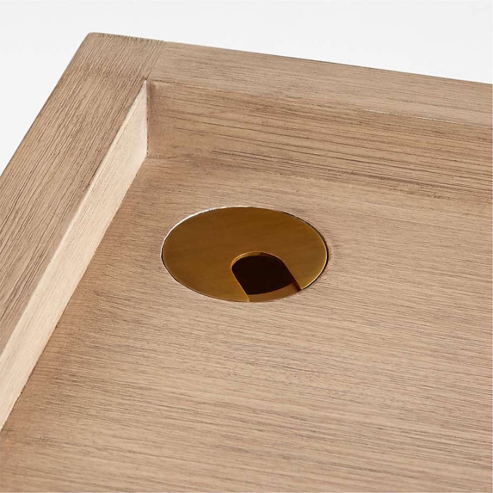 Crate & Barrel Keane 48" Weathered Natural Wood Desk with Outlets detail of the brass-finished cable management grommet on the desktop