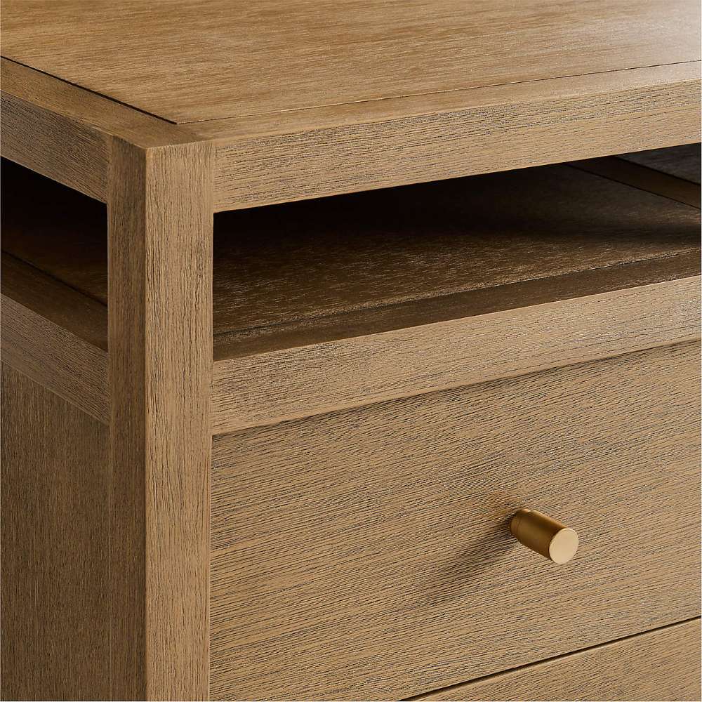 Crate & Barrel Keane 65" Solid Driftwood Desk with Outlets detail showing the driftwood finish, open shelf, and brass-finished drawer pull