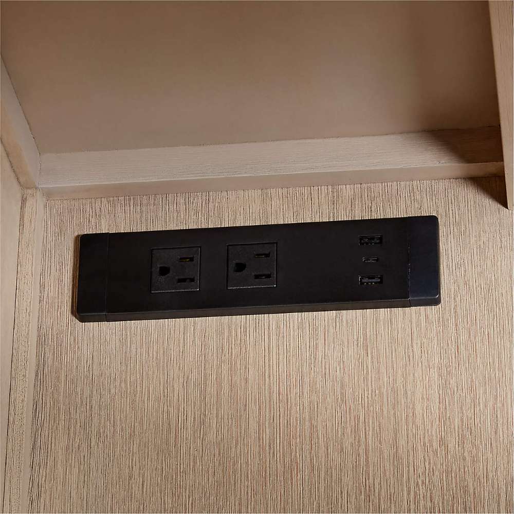 Crate & Barrel Keane 65" Weathered Natural Wood Desk with Outlets close-up of built-in power outlets and USB charging ports inside the desk