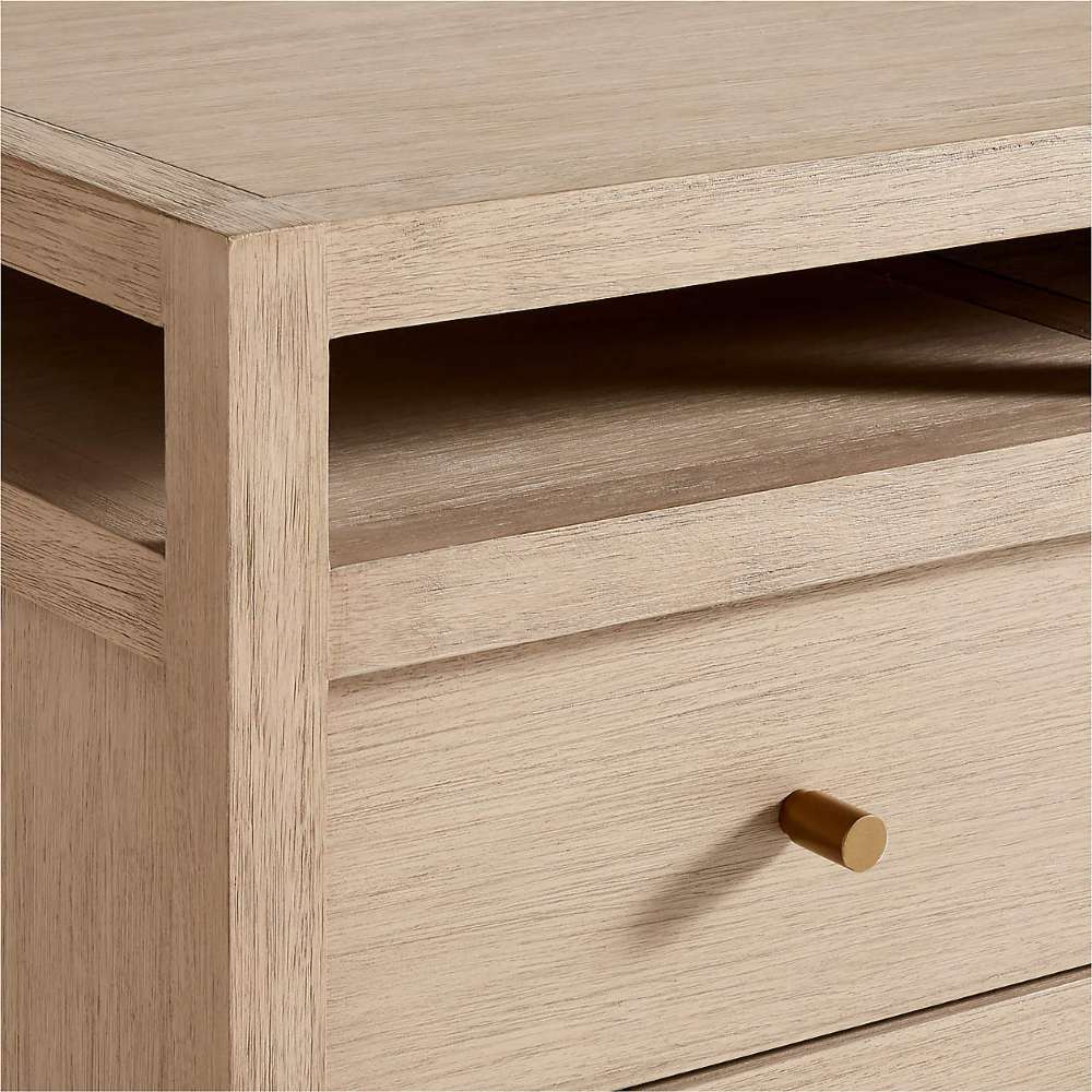 Crate & Barrel Keane 65" Weathered Natural Wood Desk with Outlets detail showing the weathered wood finish, open shelf, and brass-finished drawer pull