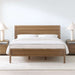 Crate & Barrel Keane Solid Driftwood King Bed centered in a bright bedroom with white bedding, matching nightstands, and table lamps