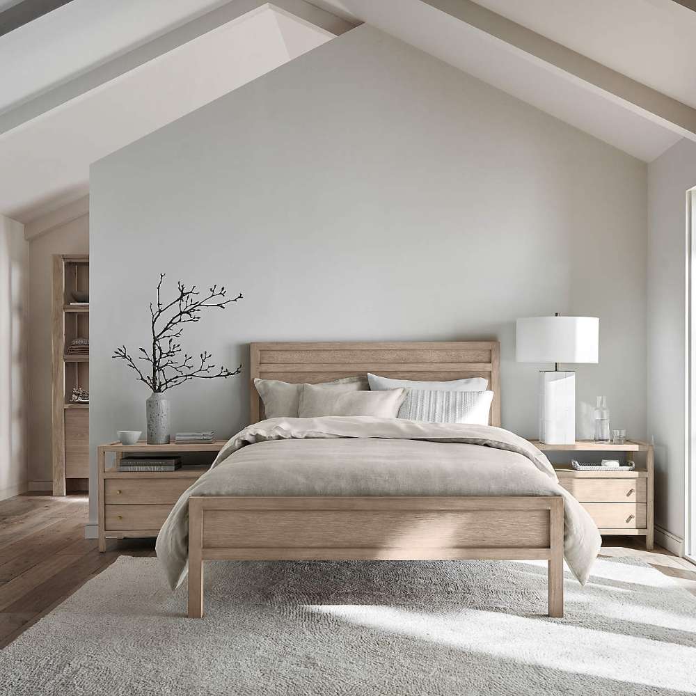 Crate & Barrel Keane Weathered Natural Solid Wood King Bed displayed in a modern bedroom with soft neutral bedding, wood nightstands, and natural light