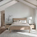 Crate & Barrel Keane Weathered Natural Solid Wood King Bed displayed in a modern bedroom with soft neutral bedding, wood nightstands, and natural light