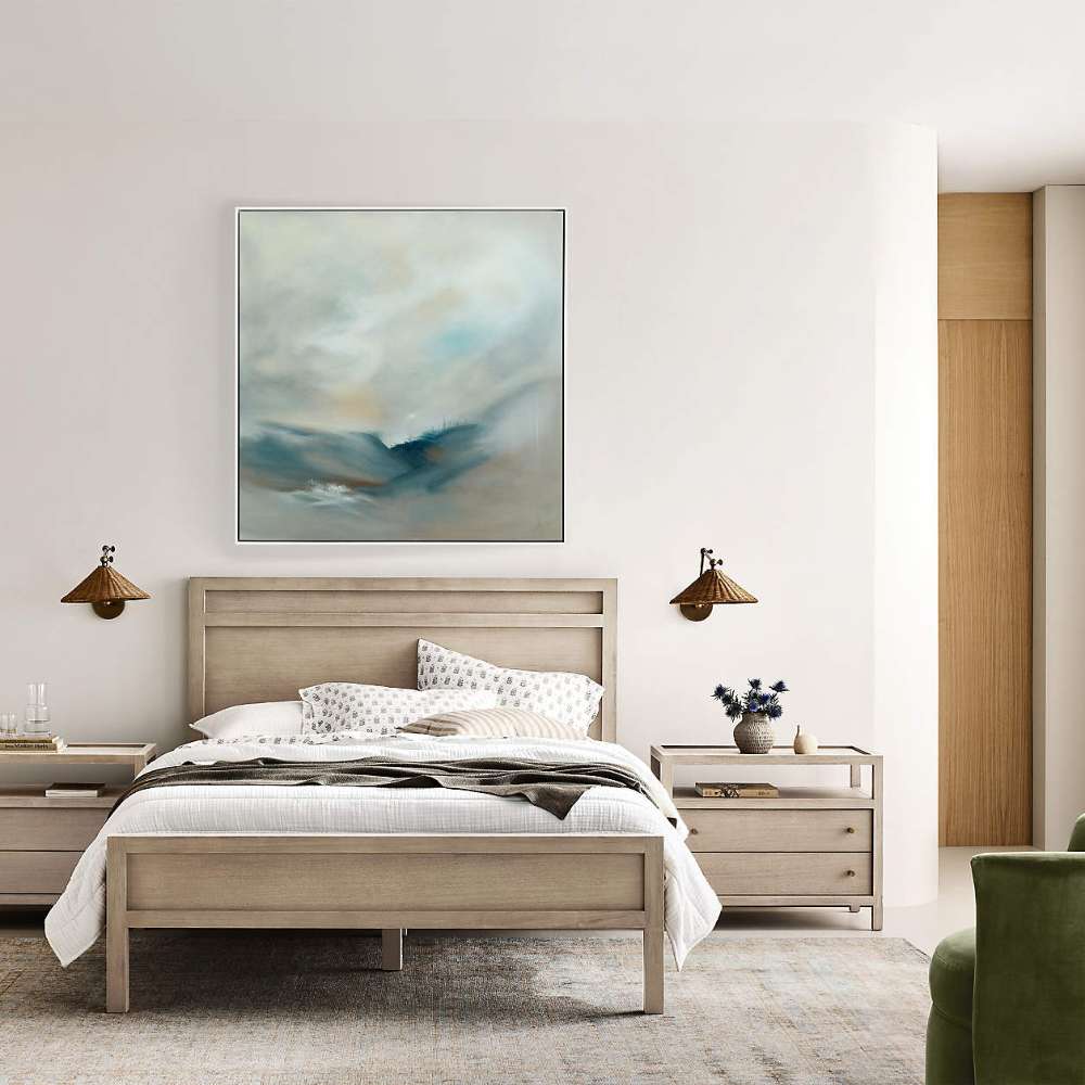 Crate & Barrel Keane Weathered Natural Solid Wood Queen Bed is styled in a bright bedroom with matching nightstands, artwork, and layered bedding
