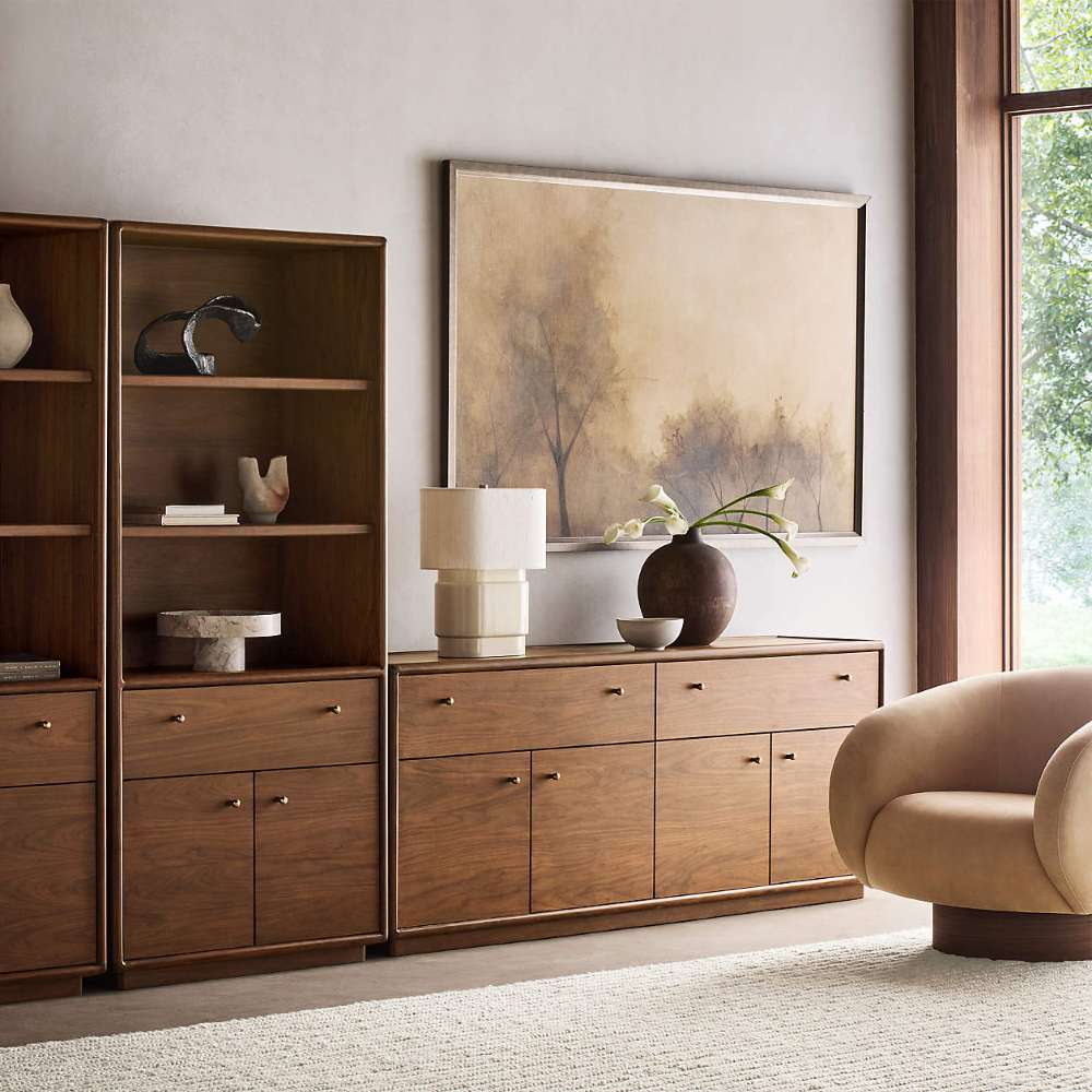 Crate & Barrel Lafayette 36" Walnut Open Storage Bookcase paired with a coordinating walnut cabinet and styled with books, sculptures, and tabletop décor