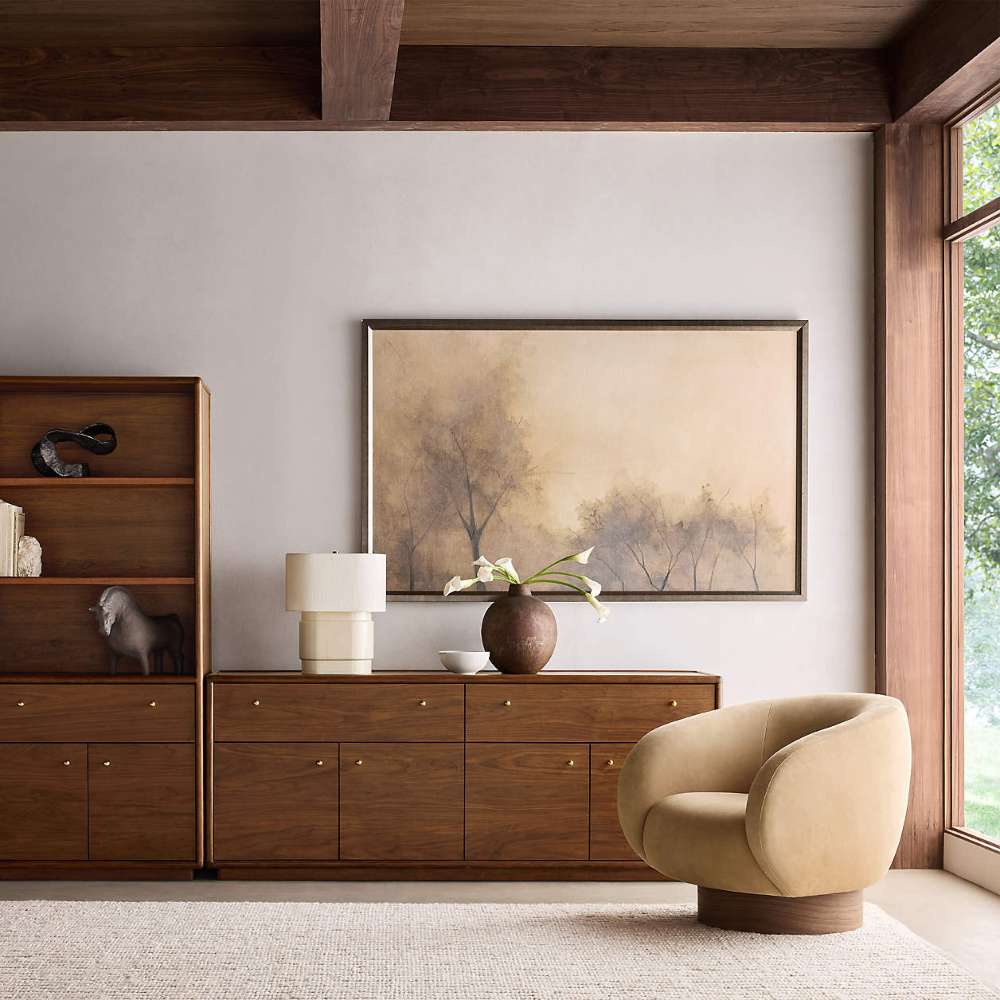 Crate & Barrel Lafayette 36" Walnut Open Storage Bookcase styled beside a walnut sideboard with decorative objects, artwork, and a modern accent chair