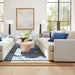 Crate & Barrel Lounge Sofa anchors a bright living room with blue accent pillows, a round coffee table, and large windows