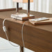 Crate & Barrel Tate 60" Walnut Desk with Outlet detail view showing a lamp and smartphone connected to the desk’s integrated power outlet and charging system