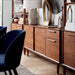 Crate & Barrel Tate 64.5" Walnut Storage Media Console styled with matching walnut furniture in a contemporary workspace