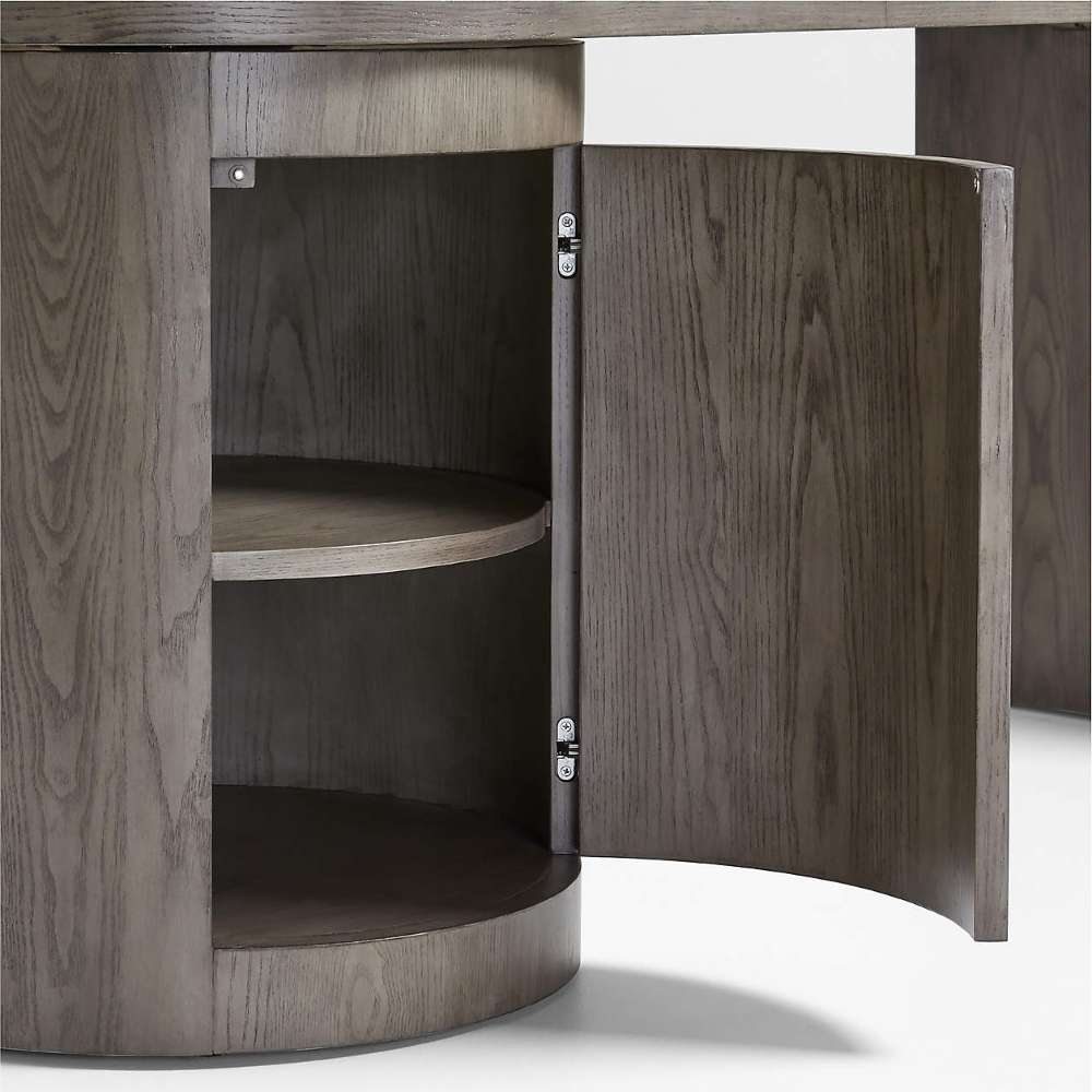 Crate & Barrel Twist 64" Grey Ash Rotating Large Desk with Storage with its cabinet door open, revealing curved interior storage shelves