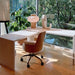 Crate & Barrel Twist 64" Whitewashed Ash Rotating Large Desk with Storage beside floor-to-ceiling windows showcasing its rotating workspace design