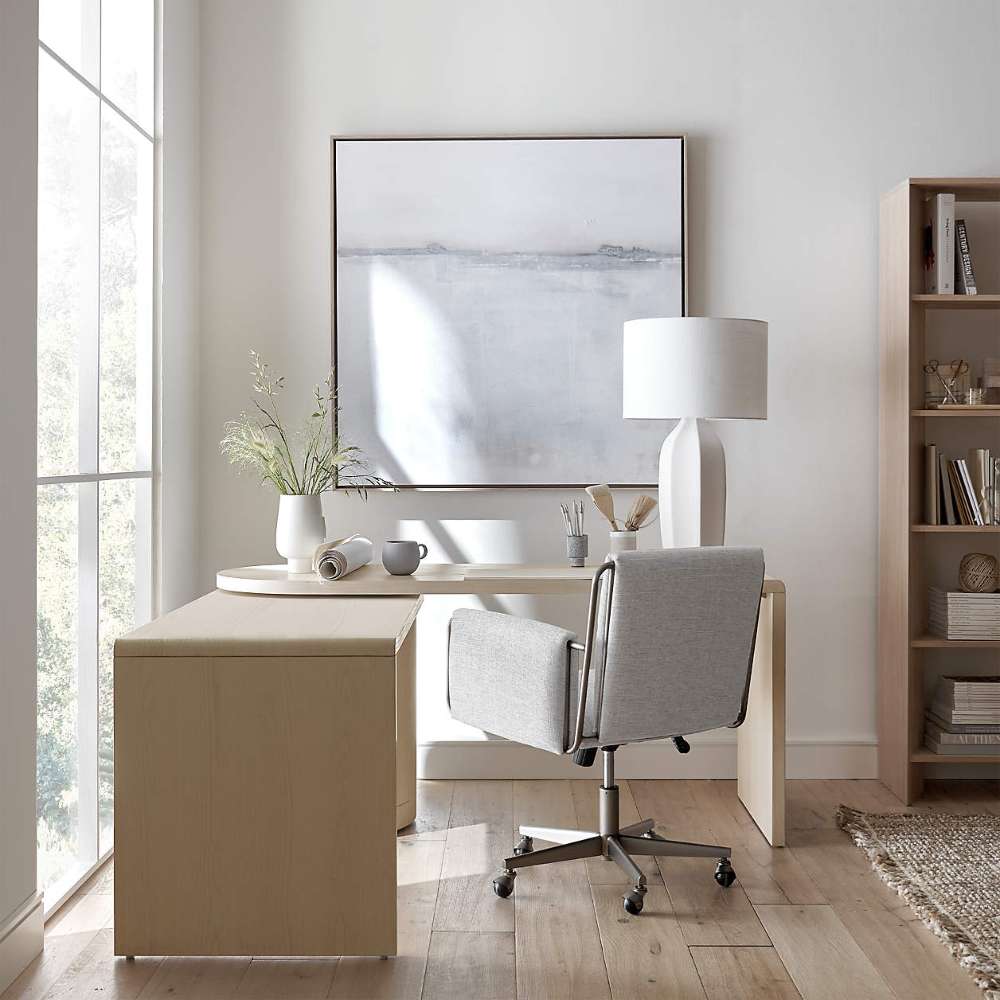 Crate & Barrel Twist 64" Whitewashed Ash Rotating Large Desk with Storage extended into an L-shaped workstation with a rolling office chair