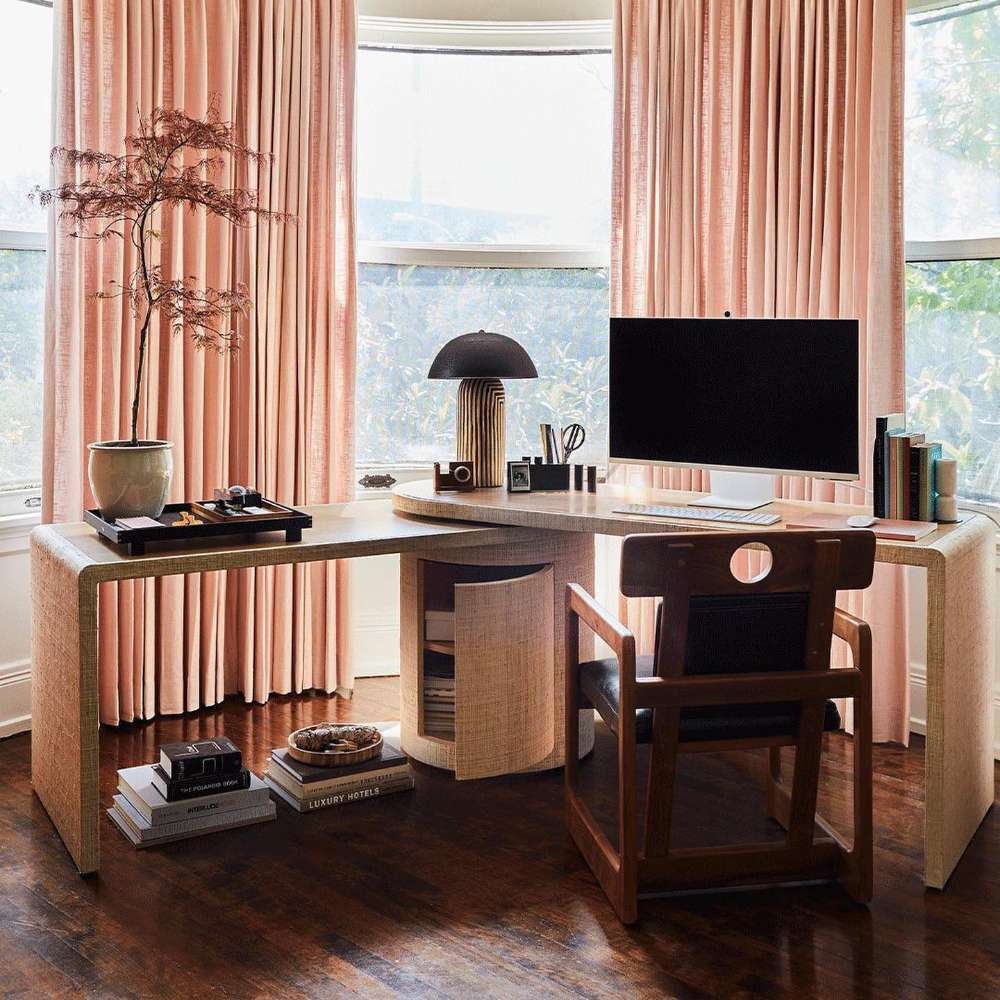 Crate & Barrel Twist 64" Whitewashed Ash Rotating Large Desk with Storage in a bright corner office with built-in storage and large surrounding windows