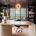 Crate & Barrel Twist 64" Whitewashed Ash Rotating Large Desk with Storage styled in a luxury office with dark bookshelves and a green swivel chair