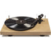 Crosley C10 Turntable - Natural displays a spinning vinyl record on its natural wood base, with a close-up focus on the tonearm and cartridge