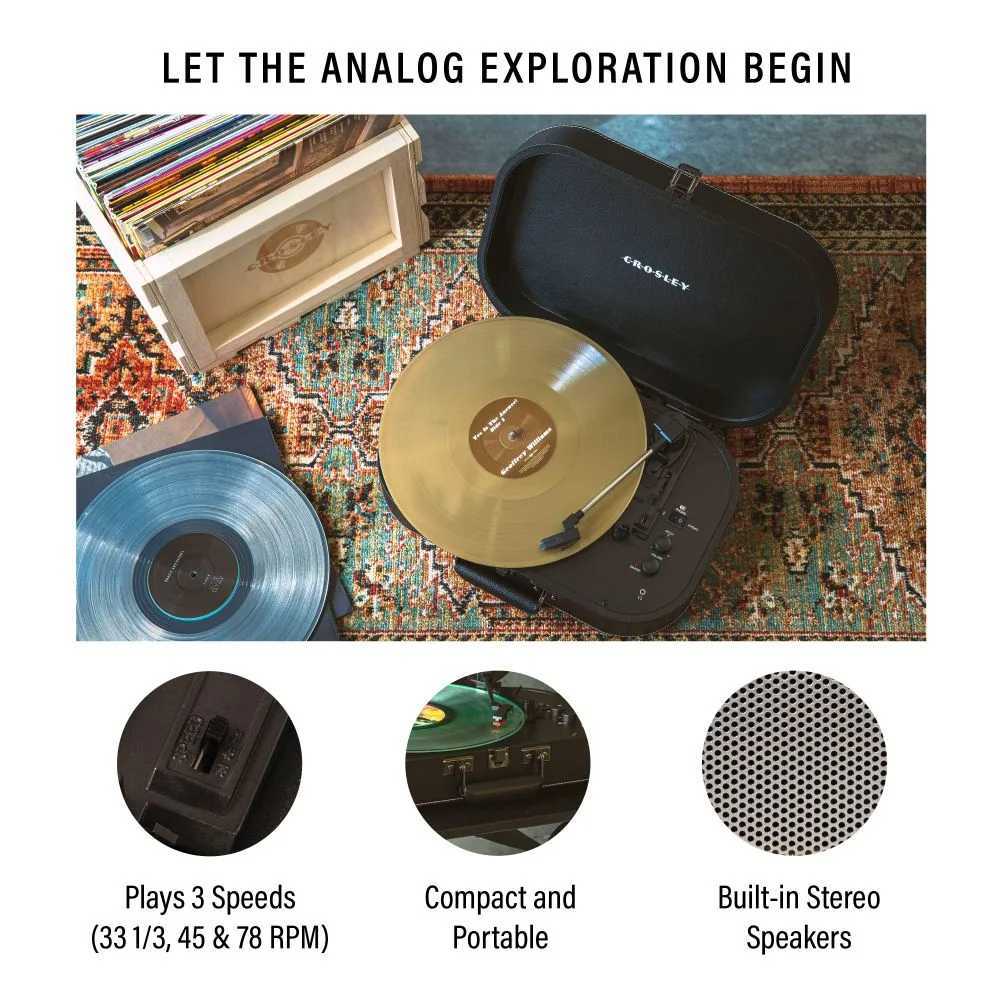 Crosley Discovery Portable Turntable with Bluetooth Out - Black is shown open on a colorful rug playing a gold vinyl record, with a wooden crate of albums nearby