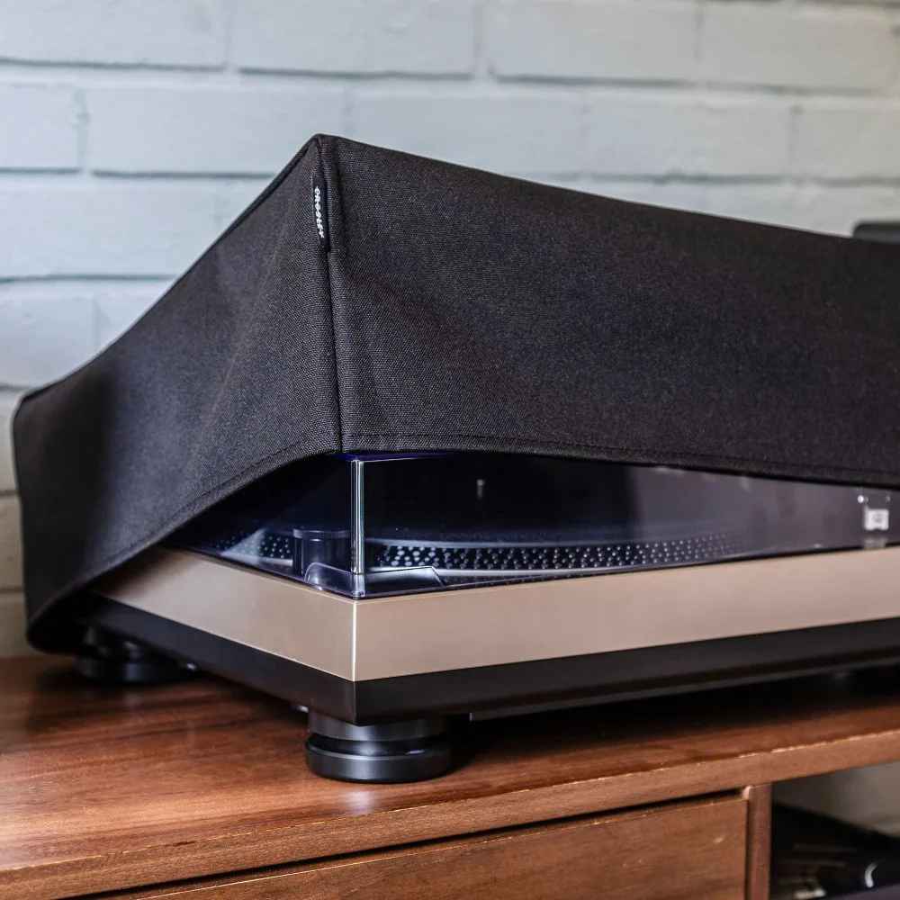 Crosley Fabric Turntable Dust Cover - Black is partially lifted, revealing its snug fit and durable material over a turntable