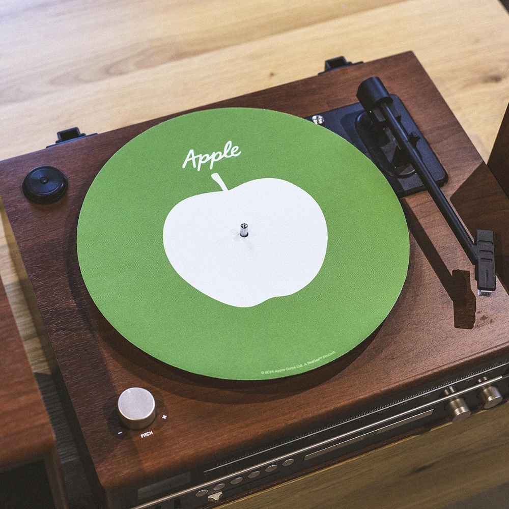 Crosley The BEATLES Platter Pad - Apple placed on a wooden turntable with a tonearm resting beside it