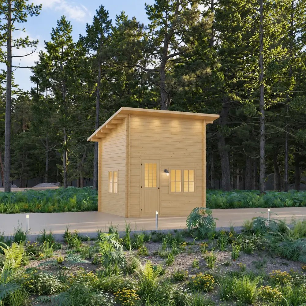 Front angled view of the Cube Loft 100 garden room with pale wood siding, a tall sloped roof, illuminated windows, modern pathway lights, and forest landscaping.