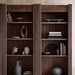 Decorative display on Crate & Barrel Siena 34" Walnut Wood 4-Shelf Storage Bookcase with Drawer showcasing books vases and sculptural accents