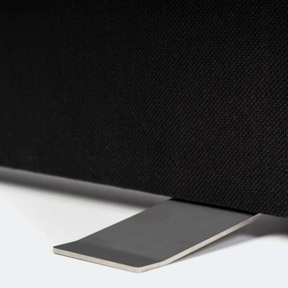 Detailed view of black GIK Acoustics Freestand Feet supporting the bottom edge of a black fabric-covered acoustic panel