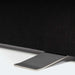 Detailed view of black GIK Acoustics Freestand Feet supporting the bottom edge of a black fabric-covered acoustic panel