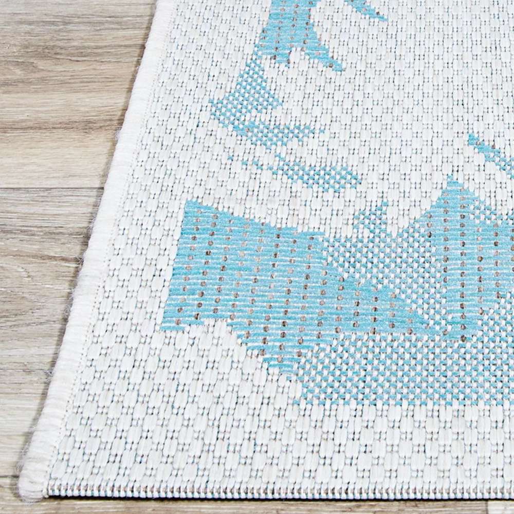 Detailed corner shot reveals the tight stitching of Couristan Monaco Indoor/Outdoor Rug - Coastal Flora/Ivory-Turquoise