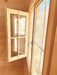 Detailed look at an open wooden-framed window letting in sunlight inside the Sawmill Structures Harvest Grand Bungalow 107 Garden Room