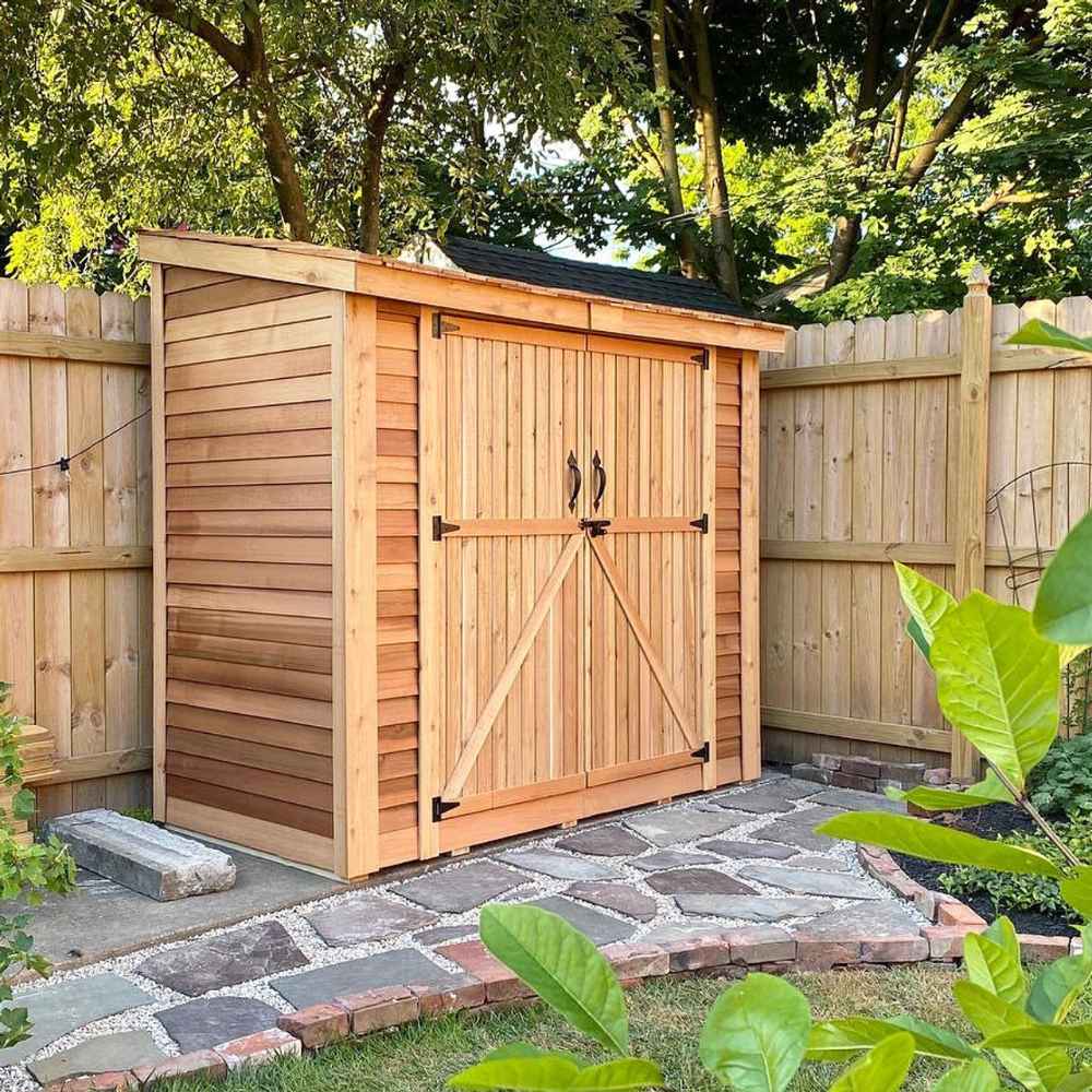 Double Door Cedar Roof Outdoor Living Today 8×4 SpaceSaver Lean-To Cedar Shed is neatly set against a wooden fence on a stone-paved area