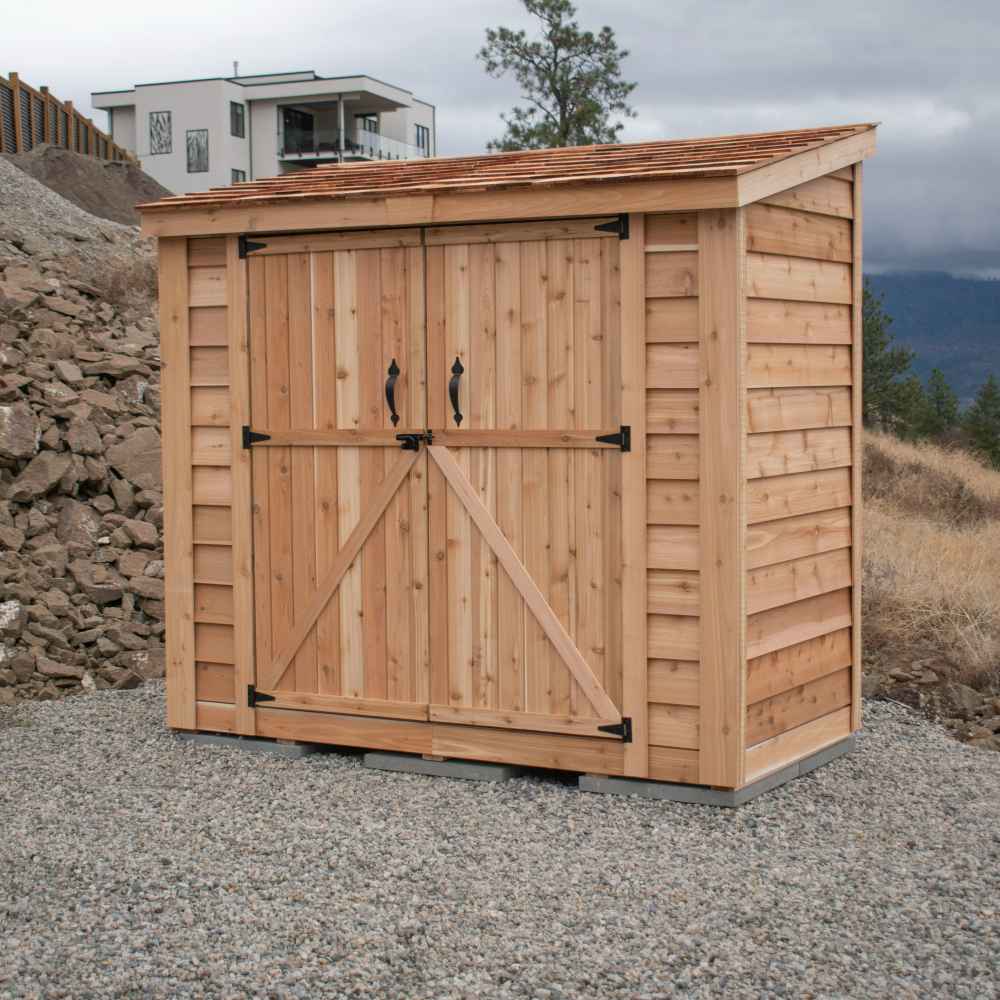 Double Door Cedar Roof Outdoor Living Today 8×4 SpaceSaver Lean-To Cedar Shed sits against a rocky backdrop with wide sliding cedar doors and a natural wood finish