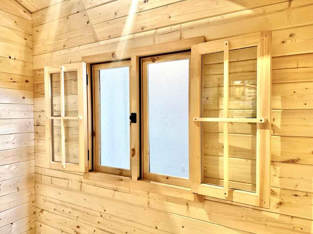 Double wooden windows with clear glass and protective outer shutters are featured inside the Sawmill Structures The Jumbo Grand Loft 130 SD Garden Room