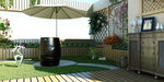 Dreampod Cold Plunge Barrel with Chiller is placed in a cozy, garden-like patio area with decorative plants, colorful flowers, and an umbrella overhead