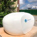 Dreampod Home Float Plus sits outdoors with a closed lid, featuring a rounded, clean design and a calm, natural backdrop